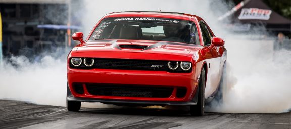 Dodge Challenger doing a burnout on a drag strip