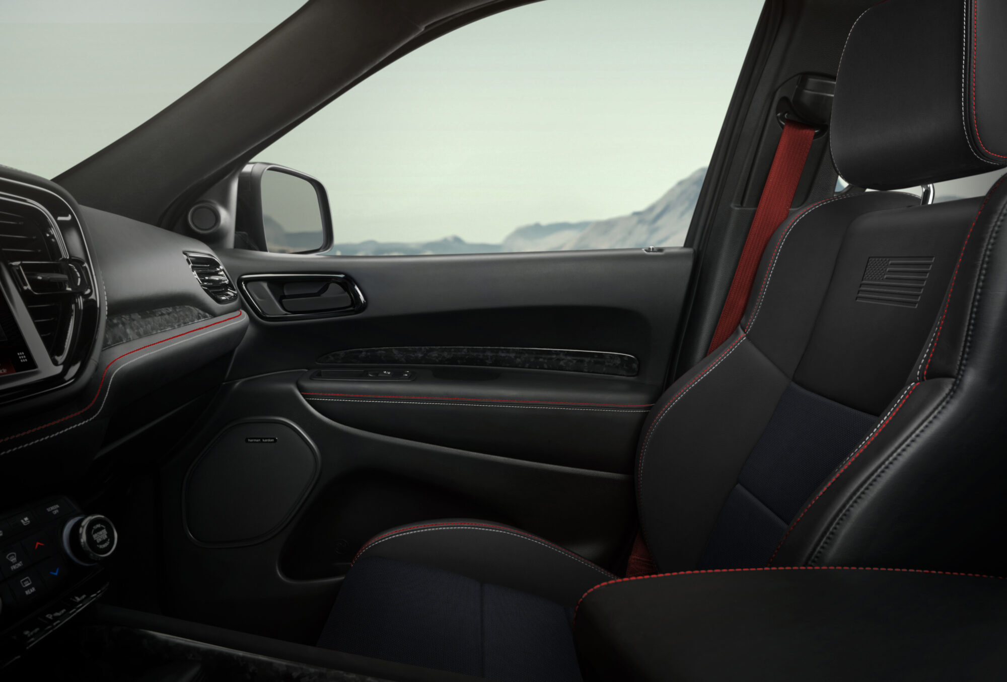 The image shows the interior of a durango, focusing on the passenger seat and door. The seats are black with red stitching, and there is a scenic mountain view visible through the window.